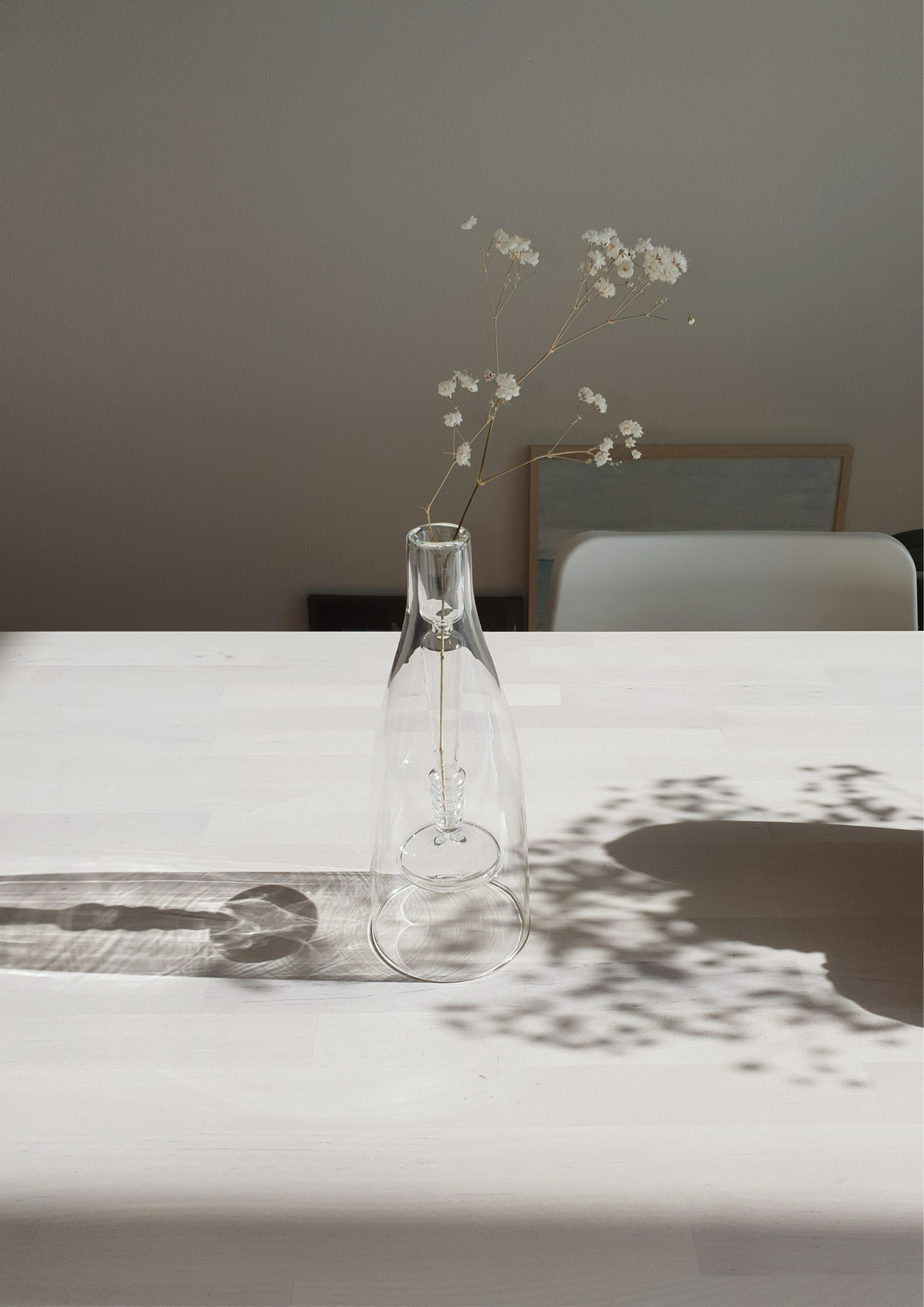 Bouteille avec des fleurs sèchées posée sur une table en bois avec nape blanche - Les panacées